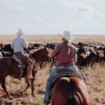 a couple of people riding on the backs of horses